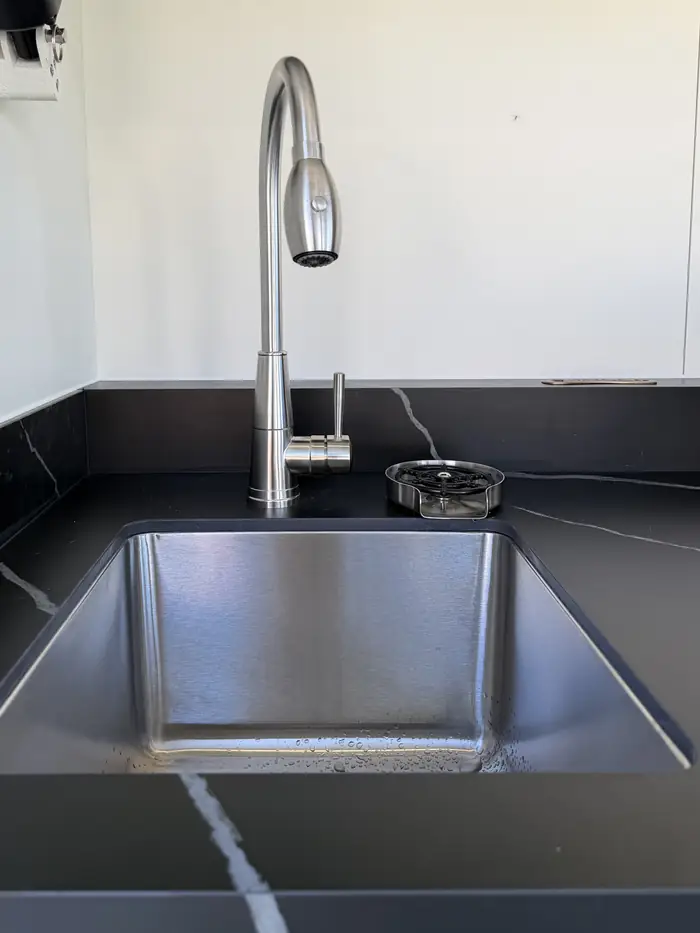 Évier inox sous plan et mitigeur à douchette de la cuisine d'extérieur Nox Pavillon installée à Albi, Tarn (81)